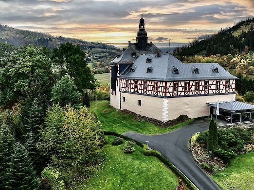 Schloss umgeben von Bäumen.