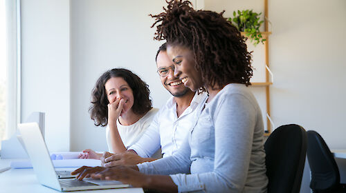 Three business people working with a laptop